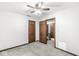 Neutral bedroom featuring plush carpeting, ceiling fan, and convenient access to additional rooms through wood-finished doors at 409 Lansdowne Rd, Indianapolis, IN 46234