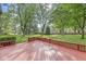 View of the backyard deck offers serene outdoor living space with lush greenery and mature trees at 409 Lansdowne Rd, Indianapolis, IN 46234