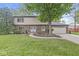 Charming two-story brick home with a well-manicured lawn and mature trees at 409 Lansdowne Rd, Indianapolis, IN 46234