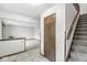 Hallway features tile flooring, wood door, and stairs to upper level at 409 Lansdowne Rd, Indianapolis, IN 46234