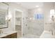 Bright bathroom featuring double sinks, a glass shower door, and marble tile at 467 Rayle Dr, Carmel, IN 46032