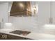 Close-up of the kitchen featuring a modern range hood, tiled backsplash, and sleek countertops at 467 Rayle Dr, Carmel, IN 46032
