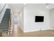 Bright living room featuring a staircase, wood floors, and a wall-mounted television at 467 Rayle Dr, Carmel, IN 46032