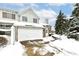 Front view of a two-story townhouse with white garage door and snowy landscape at 5921 Bastille Ln, Indianapolis, IN 46254