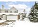 Two-story townhouse with brick and siding exterior, snow-covered landscaping, and attached garage at 5921 Bastille Ln, Indianapolis, IN 46254