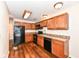 Modern kitchen with wood cabinets, black appliances, and wood-look flooring at 5921 Bastille Ln, Indianapolis, IN 46254