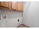 A laundry room with oak cabinets, utility hookups and gray walls, a simple yet functional space at 10695 Kyle Ct, Fishers, IN 46037