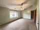 Corner bedroom with neutral carpet, ceiling fan and a large window for natural light at 12216 Laurelwood Ct, Indianapolis, IN 46236