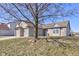 A sunny day highlights this single-story home with attached two car garage, brick accents, and a mature tree at 12216 Laurelwood Ct, Indianapolis, IN 46236