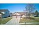 A sunny day highlights this single-story home with attached two car garage, brick accents, and a mature tree at 12216 Laurelwood Ct, Indianapolis, IN 46236