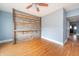 Hardwood floor living room with ceiling fan and rustic wood wall; view to dining area at 1453 Central Ave, Noblesville, IN 46060