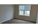 Simple bedroom with neutral walls, carpet, and a window at 5709 Woodland Way, Indianapolis, IN 46254