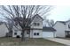 Two-story house with attached garage and a tree in the front yard at 5709 Woodland Way, Indianapolis, IN 46254