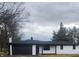 Charming exterior of a brick home with a black garage door and mature trees at 6805 E County Road 100 S, Avon, IN 46123