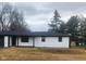 A brick home with black accents on a lush, green lot with mature trees at 6805 E County Road 100 S, Avon, IN 46123