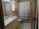Bathroom with a white vanity, toilet, cabinet and a shower with a patterned curtain at 7099 S 1100 W, Jamestown, IN 46147