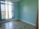 Bright bedroom features a large window, blue curtains, and wood-look flooring at 7099 S 1100 W, Jamestown, IN 46147