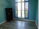 A well-lit room featuring light blue walls, wood-look floors, and a closet at 7099 S 1100 W, Jamestown, IN 46147
