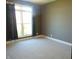 Bright bedroom with a large window dressed with dark curtains, and plush carpeted floors at 7099 S 1100 W, Jamestown, IN 46147