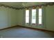 Carpeted bedroom with floral wallpaper border, three windows, and ceiling fan at 7099 S 1100 W, Jamestown, IN 46147