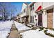 Townhouse exterior showcasing a red awning and snow-covered landscaping at 8021 E 20Th St, Indianapolis, IN 46219