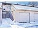 Attached garage with a large door and snow on the ground at 8021 E 20Th St, Indianapolis, IN 46219
