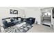 Living room features a blue sofa, armchair, and view of the kitchen at 8021 E 20Th St, Indianapolis, IN 46219