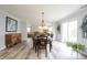 Dining area with hardwood floors, modern lighting and access to the living room at 10406 Corning Way, Fishers, IN 46038