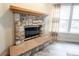 Close-up view of a stone fireplace with a wooden mantle and hearth at 10406 Corning Way, Fishers, IN 46038