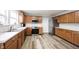Spacious kitchen showcasing wooden cabinets, stainless steel appliances, and durable wood-look flooring at 10406 Corning Way, Fishers, IN 46038