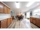 Open-concept kitchen with wooden cabinetry, light countertops, and a view into the dining and living areas at 10406 Corning Way, Fishers, IN 46038