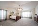 Bright main bedroom featuring a ceiling fan, neutral carpet, and light from several windows at 10406 Corning Way, Fishers, IN 46038
