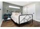 Cozy bedroom with a metal bed frame, green accent wall, and wood floors at 1306 Olive St, Indianapolis, IN 46203