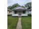 White brick home with a front porch and landscaped lawn at 1445 W 34Th St, Indianapolis, IN 46208