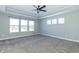 Primary bedroom with tray ceiling, carpet, and large windows at 16172 Sedalia Dr, Fishers, IN 46040