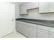 Laundry room with gray cabinets, dark countertop, and tile floor at 16172 Sedalia Dr, Fishers, IN 46040