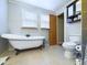 Bathroom with clawfoot tub, toilet and wood door at 1729 Bittersweet Dr, Anderson, IN 46011