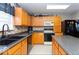 Kitchen with wood cabinets, black appliances, and tile backsplash at 1735 Sonesta Ln, Indianapolis, IN 46217