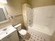 Bathroom with white tub, toilet, and sink; black and white tile floor at 2817 N New Jersey St, Indianapolis, IN 46205