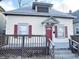 Beige house with red shutters, a red door, and a wooden deck at 2817 N New Jersey St, Indianapolis, IN 46205