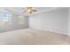 Spacious bedroom with neutral walls and carpet, featuring a ceiling fan and multiple windows at 3 Lakewood Dr, Trafalgar, IN 46181