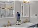 Modern bathroom featuring double sinks with gold fixtures, illuminated mirrors, and a glass-enclosed shower at 304 N College Ave # Apt A, Indianapolis, IN 46202