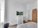 Bright bedroom with a mounted flat screen television and white dresser at 304 N College Ave # Apt A, Indianapolis, IN 46202