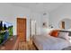 Bedroom with hardwood floors, a mounted television and a doorway to another room at 304 N College Ave # Apt A, Indianapolis, IN 46202