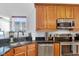 Cozy kitchen with stainless steel appliances, granite counters, and wood cabinets at 304 N College Ave # Apt A, Indianapolis, IN 46202