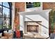Well-lit living room showcasing a white fireplace, exposed brick wall, ladder, and large window at 304 N College Ave # Apt A, Indianapolis, IN 46202