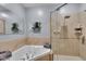 Bright bathroom features a jetted tub and glass-enclosed shower with tiled walls and a built-in shelf at 304 N College Ave # Apt B, Indianapolis, IN 46202