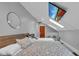Bright bedroom features skylights, two beds, hardwood door, modern round mirror and wall mounted television at 304 N College Ave # Apt B, Indianapolis, IN 46202
