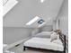Attic bedroom features skylights with mounted TV and three twin beds with neutral decor at 304 N College Ave # Apt B, Indianapolis, IN 46202