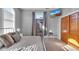 Bright bedroom with gray walls features access to a balcony, a TV, and a convenient luggage rack at 304 N College Ave # Apt B, Indianapolis, IN 46202